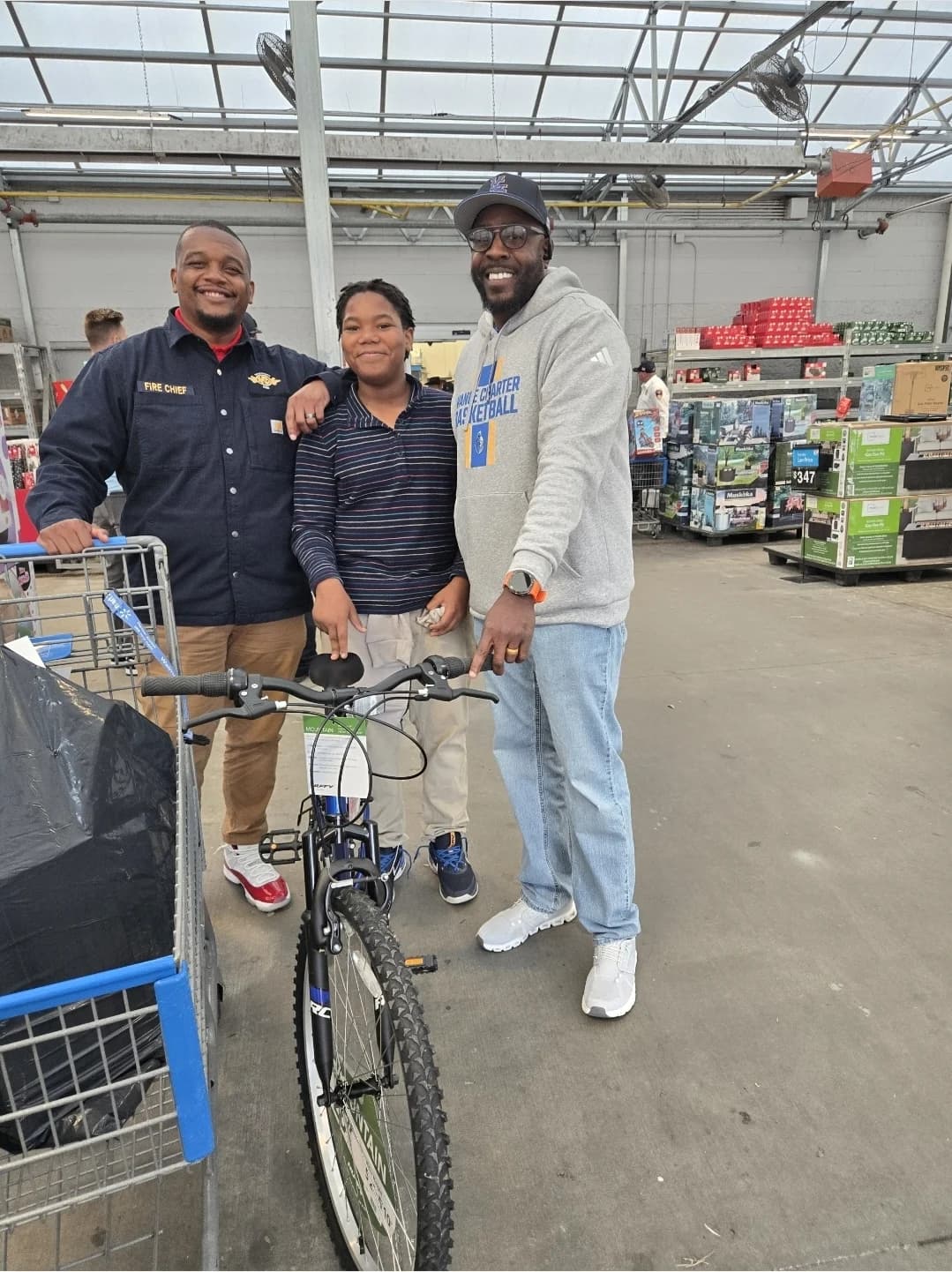 CJ Turrentine with a fire chief and a young person at a bicycle event