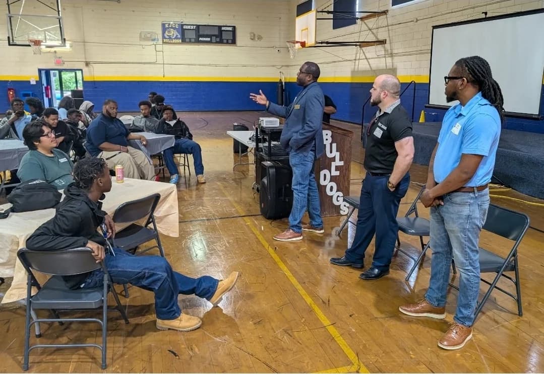 CJ Turrentine speaking with young people and community partners in a gym